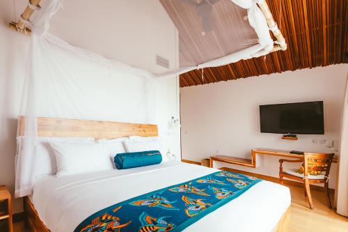a bedroom with a large bed and a tv at Hemingways Retreat Kigali in Kigali