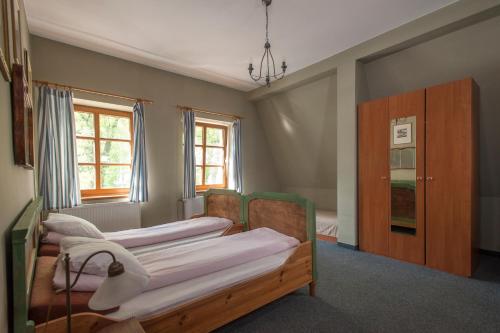 um quarto com 4 camas, um armário e janelas em Dworek pod Herbem em Gądkowice