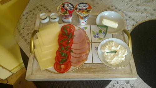 a table with a tray of food with meat and vegetables at Słoneczne apartamenty in Sobótka