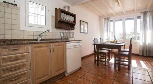 cocina con fregadero y mesa con sillas en Casa Tiati, en Puerto del Carmen