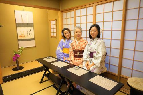 three women in kimonos standing in a room at Morizuya in Toyooka