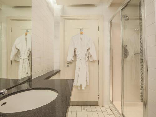 La salle de bains est pourvue d'une baignoire et d'une robe blanche. dans l'établissement Prince of Wales Hotel, à Athlone