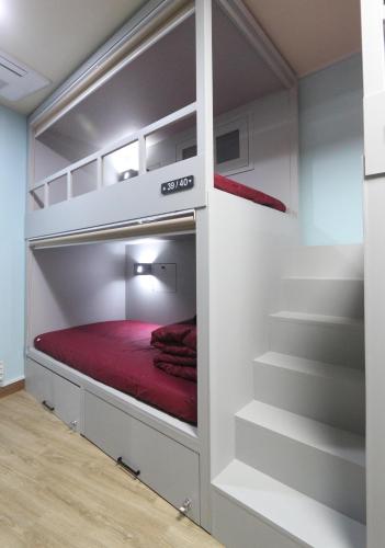a bed in a bunk bed room with stairs at Daegu Midtown Hostel in Daegu