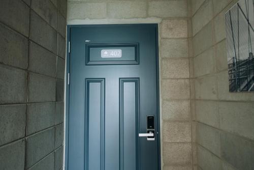 a blue door with the number on it at Daegu Midtown Hostel in Daegu