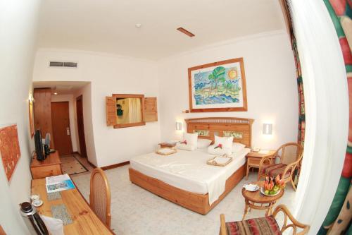 una camera d'albergo con letto e tavolo di The Oasis Beach Resort a Hambantota