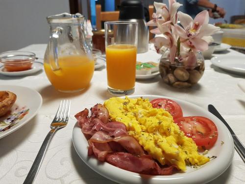 a table with a plate of breakfast food and orange juice at Casa dos Tios in Fátima