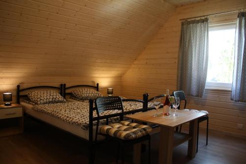 a bedroom with a bed and a table with a table sidx sidx sidx at Domki letniskowe in Pobierowo