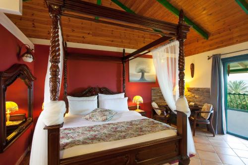 a bedroom with a canopy bed in a room at Out of Africa Resort in Had Nes