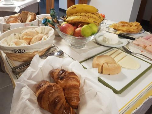 a table topped with different types of bread and pastries at Casa dos Tios in Fátima