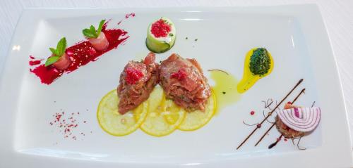 a plate of food with meat and fruit on it at Hotel Panorama in Šibenik
