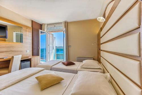 a hotel room with two beds and a window at Hotel Panorama in Šibenik