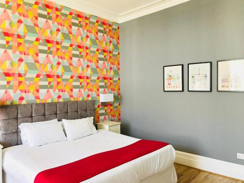 a bedroom with a bed with a colorful wall at Da Vinci Eastbourne in Eastbourne