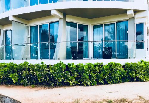 a building with windows and bushes in front of it at Nilaveli Ocean Condos in Trincomalee