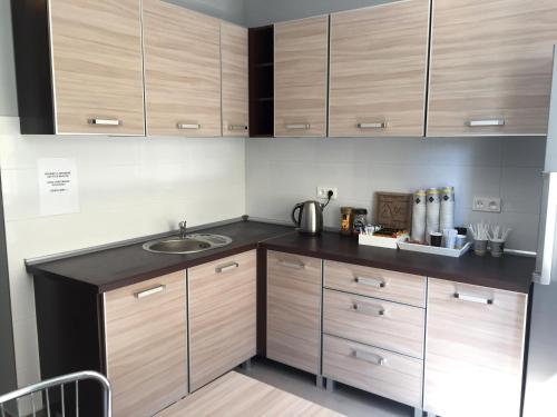 a kitchen with wooden cabinets and a sink at da Massimiliano in Wrocław