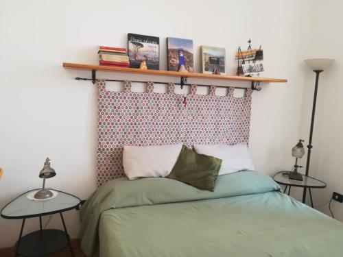 1 dormitorio con 1 cama con un estante encima en B&B Al Ponte, en Nápoles