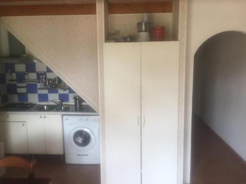 eine Küche mit einer Spüle und einer Waschmaschine in der Unterkunft Appartamento La Valle in Marina Romea