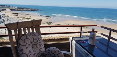 a chair sitting on a balcony with a view of the beach at Porto Sea Apartments in Matosinhos