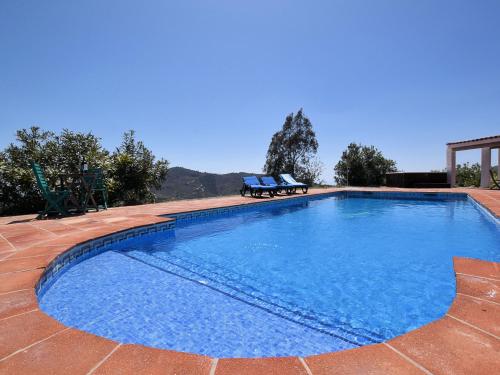 a large swimming pool with two chairs sitting around it at Belvilla by OYO Villa Bandoleros in Arenas