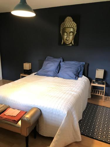 a bedroom with a large bed with a head on the wall at Maison LES BLEUETS in Le Perréon