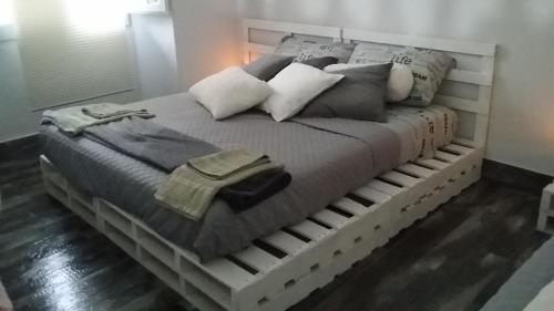 a wooden bed with pillows on top of it at Casa Del CicloTurista in Santadi