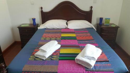 a bed with two white towels on top of it at Residencia Mateus in Faja Grande