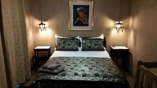 a bedroom with a large bed with two night stands at The Yardt Guest House in Trichardt