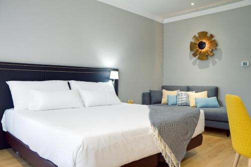 a bedroom with a large bed and a couch at Oca Puerta del Camino Hotel in Santiago de Compostela