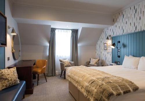 una camera d'albergo con un grande letto e una scrivania di Solent Hotel and Spa a Fareham