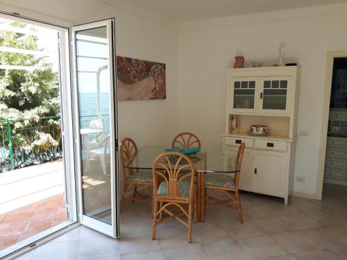 a dining room with a table and chairs and a sliding glass door at Villa Giuliana in Pisciotta