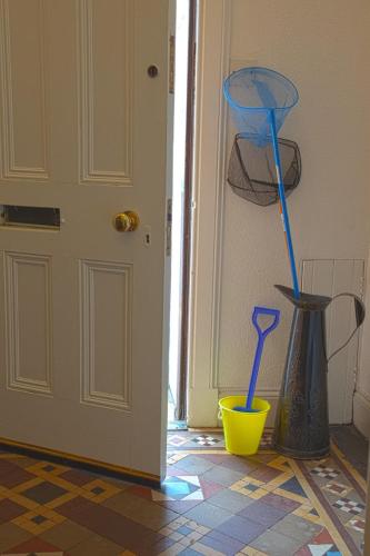 a door with two spoons in a yellow bowl and a vase at Auld Leigh-Lann Apartments in Anstruther