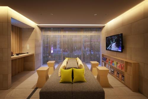 東京的住宿－濱松町京王布萊索經濟型酒店，客厅配有沙发和墙上的电视