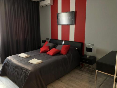 a bedroom with a bed with red and white stripes at Bon apetit apartament in Lviv