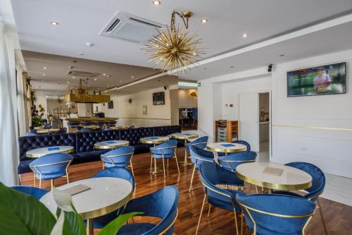 a dining room with tables and blue chairs at Art Hotel in Split