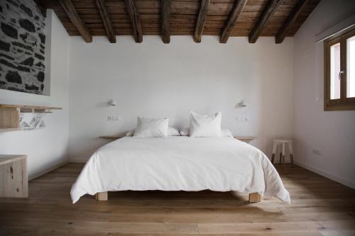 1 dormitorio blanco con 1 cama grande con sábanas blancas en Izal Landetxea, en Bergara