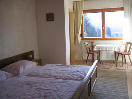 a bedroom with two beds and a table and a window at Haus Zwischenberger in Dölsach