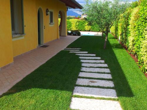 a garden with a tree and a walkway at Villa Oliva in Manerba del Garda