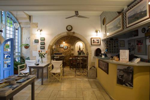 ein Restaurant mit einer Theke und Stühlen in einem Zimmer in der Unterkunft Nostos Hotel in Chania