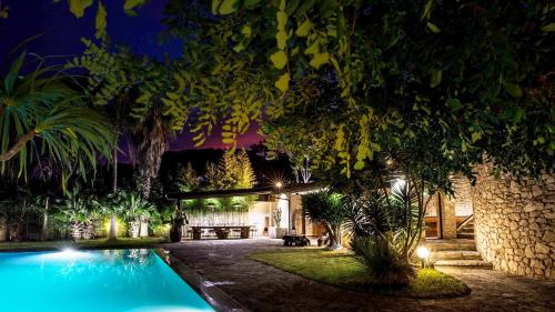 una casa con piscina di notte di La Villa Apartments a Torre dell'Orso