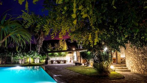 a house with a swimming pool at night at La Villa Apartments in Torre dell'Orso