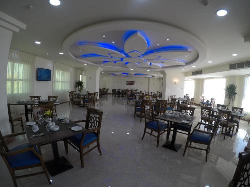 a restaurant with tables and chairs and a blue ceiling at Rehana Plaza Hotel in Cairo