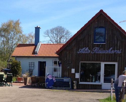 a barn with a person sitting outside of it at Haus Vicus in Greifswald