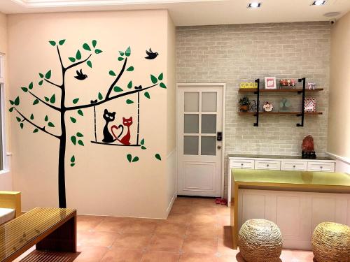 a kitchen with a tree and birds on the wall at Moumoon B&B in Magong