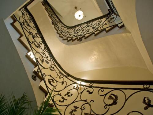 a staircase with a mirror and a wrought iron railing at Bellavilla in Vilnius