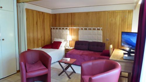 a hotel room with a bed and two chairs at Garden Studio Chantilly in Chantilly