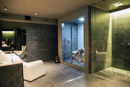 una persona está en un baño con ducha en Arborina Relais, en La Morra