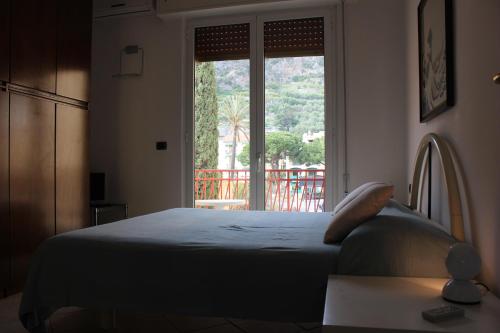una camera con un letto e una grande finestra di Les Agrumes a Varigotti