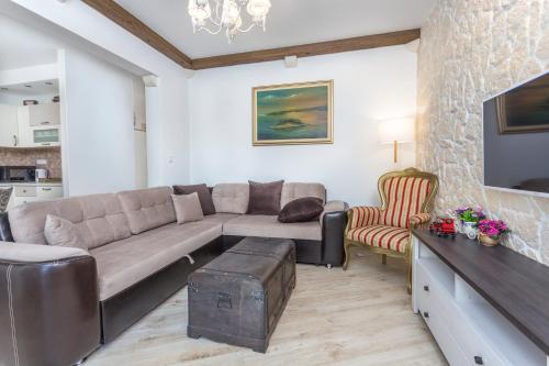 a living room with a couch and a tv at Villa Capitis in the center - Apartment with private pool in Hvar