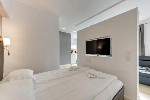 グディニャにあるGdynia Comfort Apartments Władysława IVの白いベッドルーム(ベッド1台、薄型テレビ付)