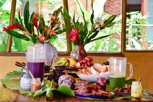 a table filled with food and drinks and flowers at Banana Bamboo Ecolodge in Ubatuba