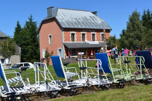 a group of chairs sitting in the grass in front of a building at gite chez Régine in Marcenat